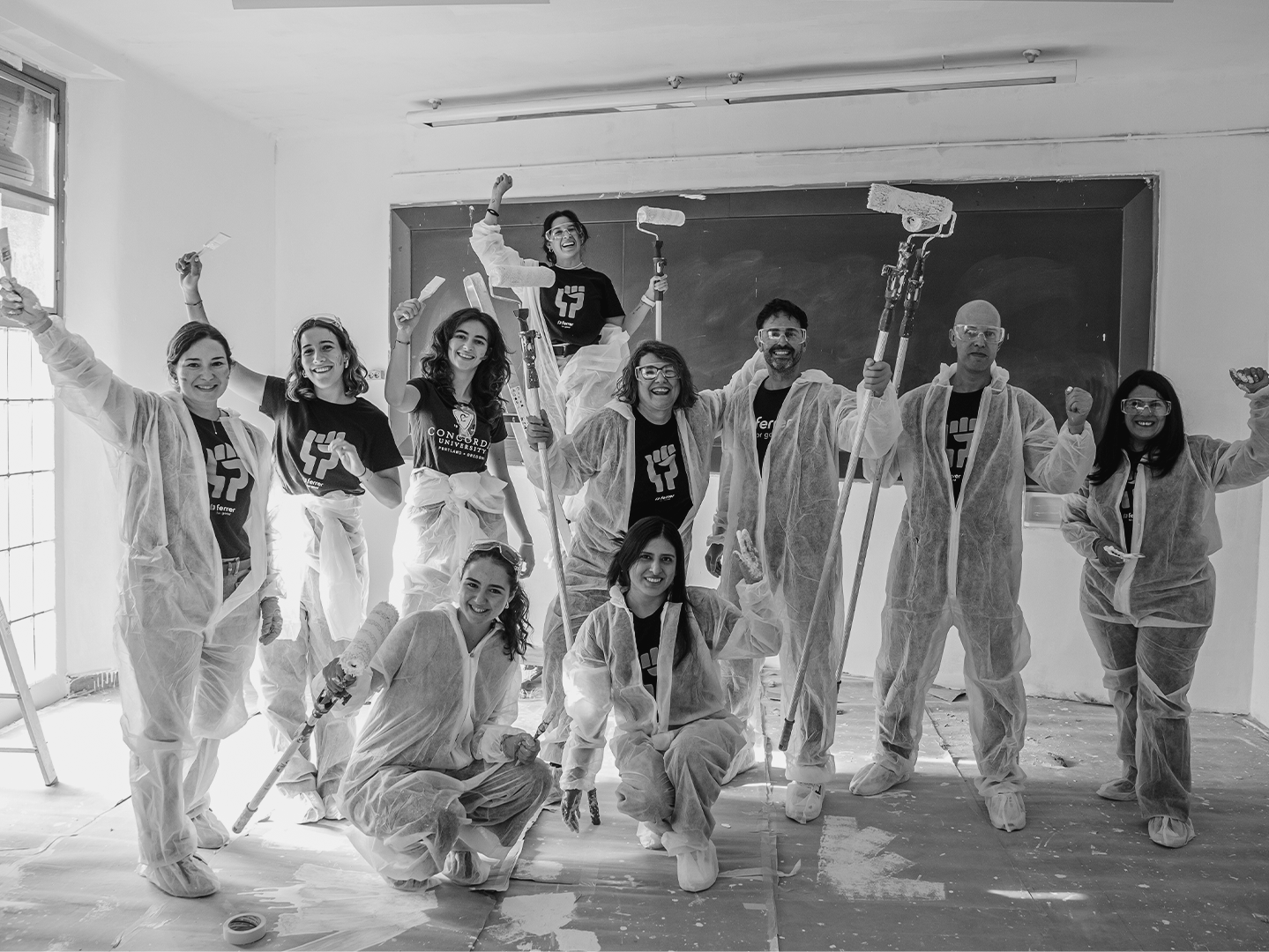 A team of volunteers from Grupo Ferrer in a collective action painting a school classroom during a day of volunteering.