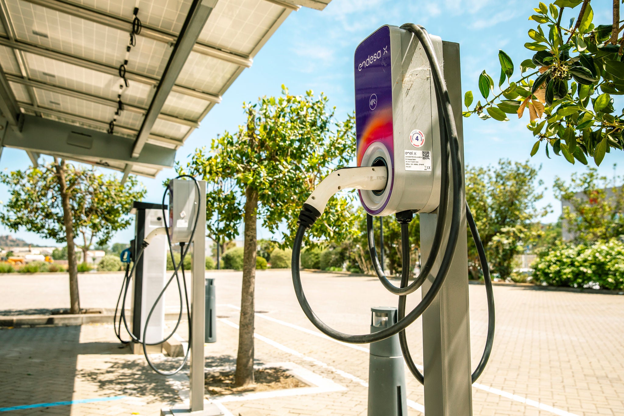 Punts de recàrrega per a vehicles elèctrics instal·lats a l'aire lliure a les oficines de Ferrer, reflectint el compromís de l'empresa amb la mobilitat sostenible.