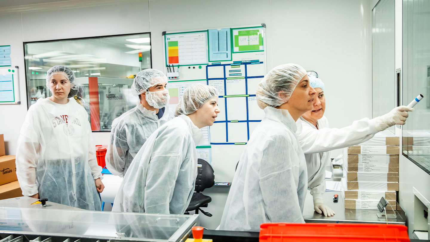 Equipo de operarios en una sala blanca de fabricación farmacéutica, liderando la gestión operativa de la cadena de valor de Ferrer.