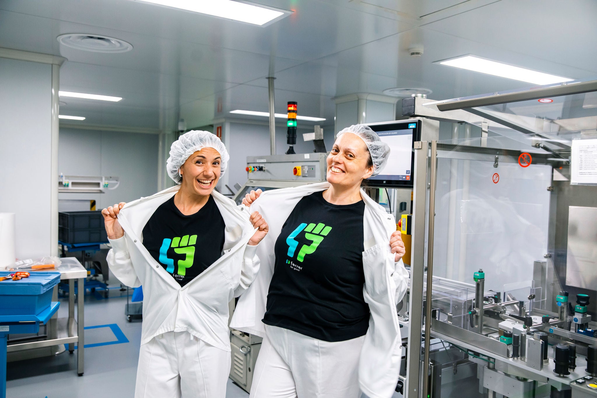 Two employees of Grupo Ferrer showing their corporate t-shirt at the production plant.