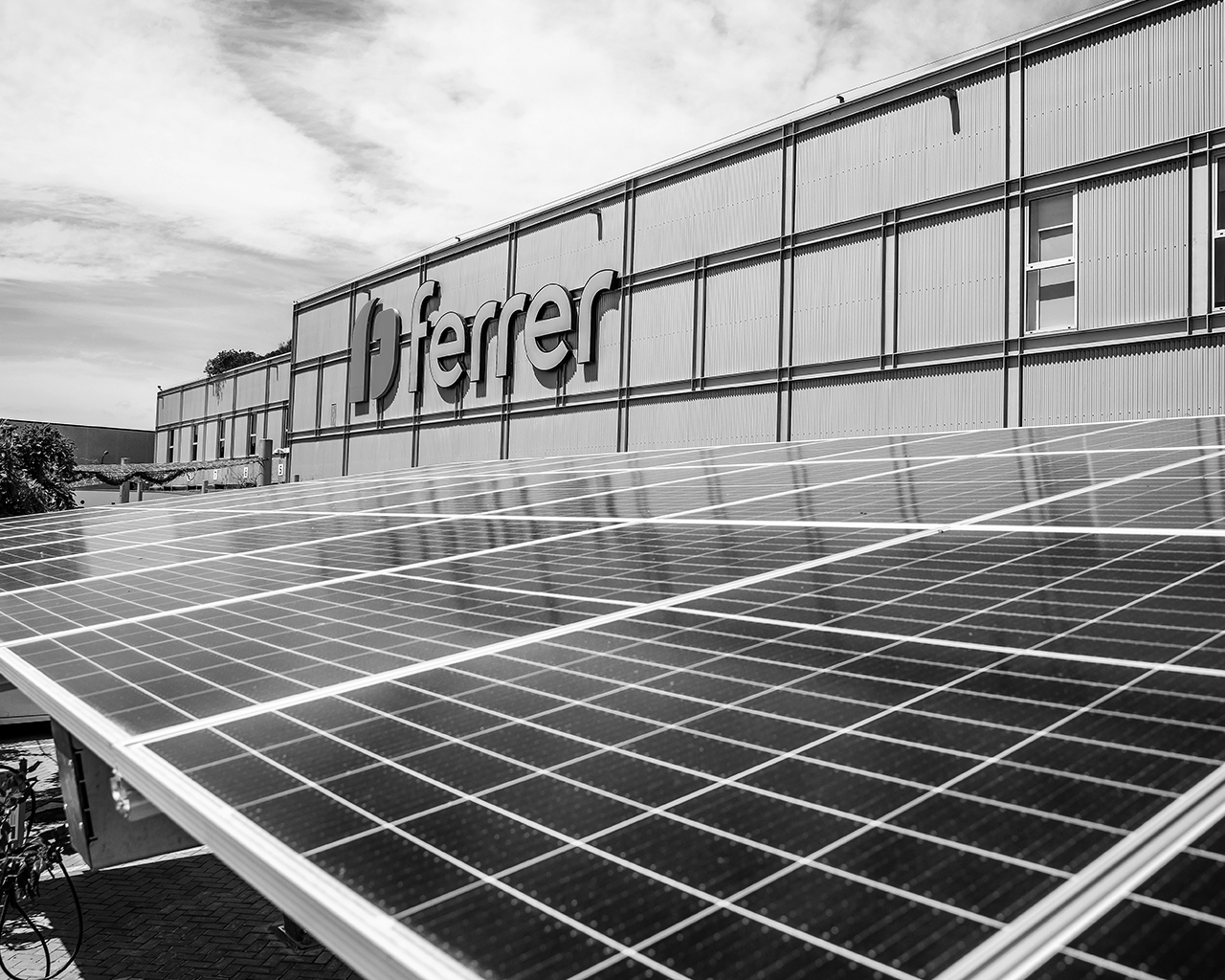 Paneles solares instalados en el exterior de una planta de producción de la empresa Ferrer para fomentar el uso de energía sostenible.