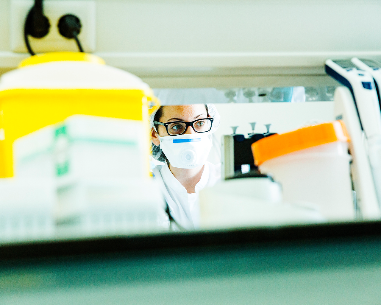 Una investigadora con mascarilla y gafas trabajando en el laboratorio para el desarrollo de fármacos en la empresa Ferrer.