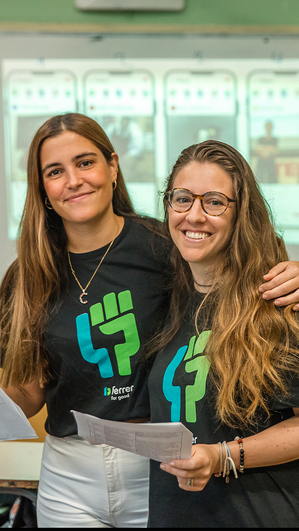Dos personas del equipo de Ferrer sonríen a cámara con camisetas corporativas durante una actividad interna de la compañía.