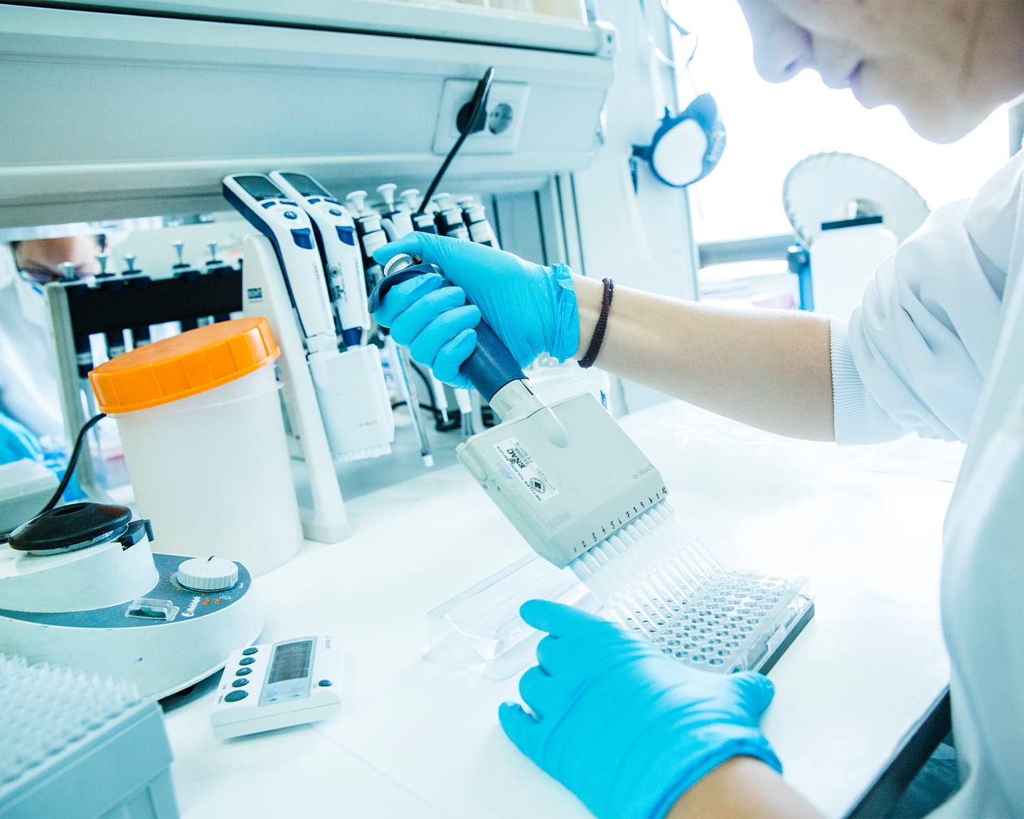 Researcher at Grupo Ferrer carrying out R+D tasks with a micropipette in the pharmaceutical laboratory.
