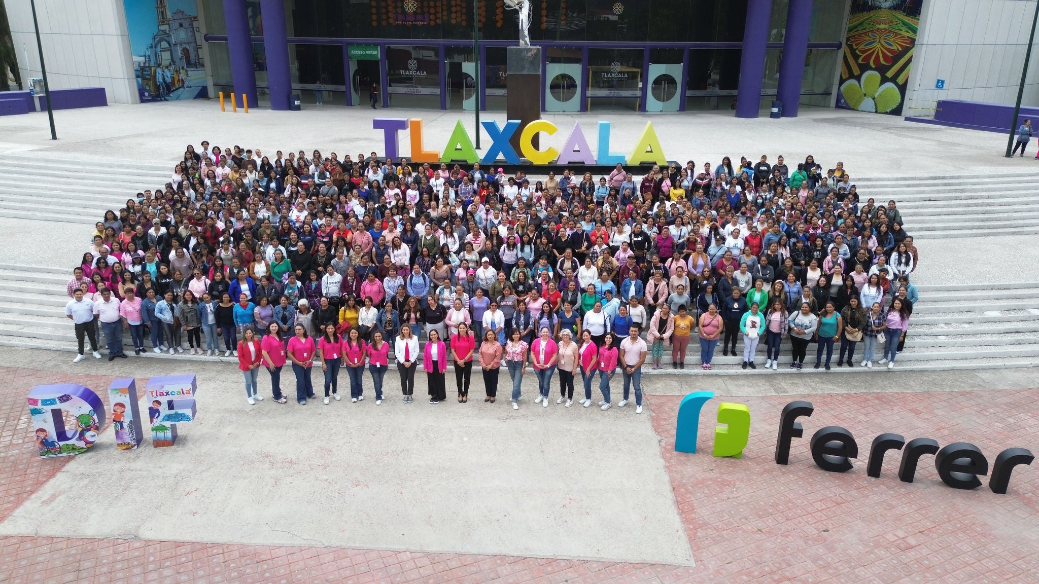 Fotografia de grup multitudinària davant un edifici a Tlaxcala, amb lletres gegants de "TLAXCALA", elements del DIF i el logotip de Ferrer en primer pla.