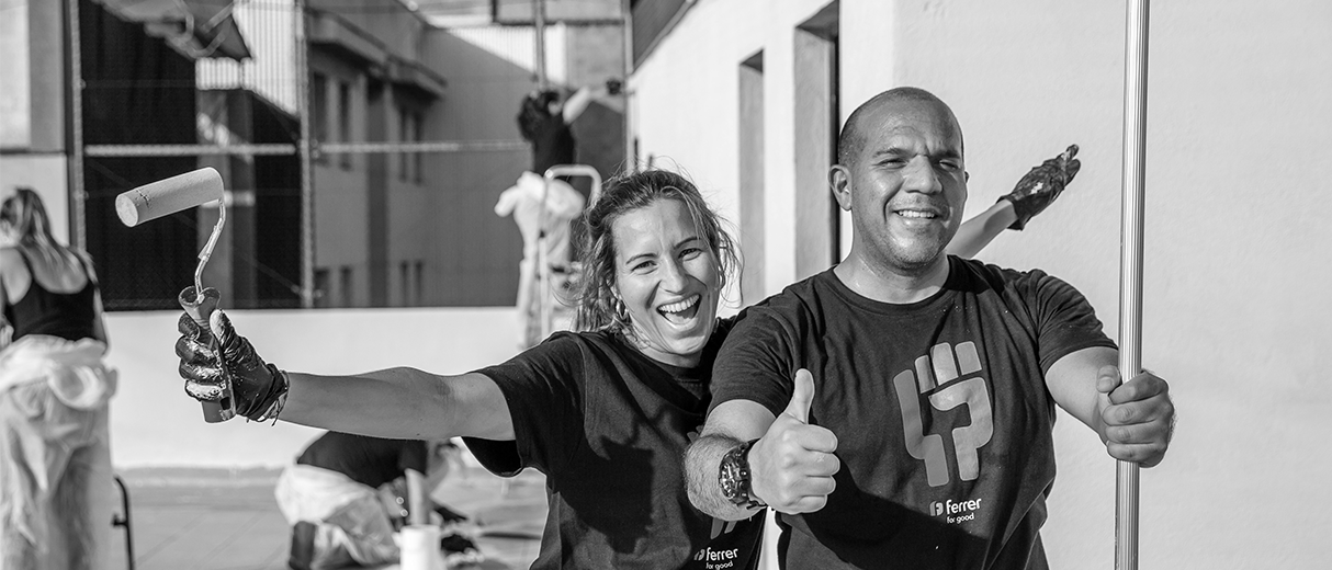 Voluntarios con camisetas de "Ferrer for good" colaborando en la rehabilitación de un espacio durante una acción social de la empresa.