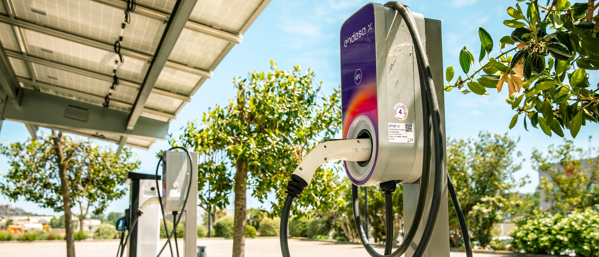 Puntos de recarga para vehículos eléctricos instalados al aire libre en las oficinas de Ferrer, reflejando el compromiso de la empresa con la movilidad sostenible.