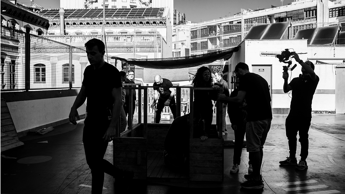 Volunteers from the Ferrer group building a sustainable wooden structure in an urban courtyard during a day of social action.