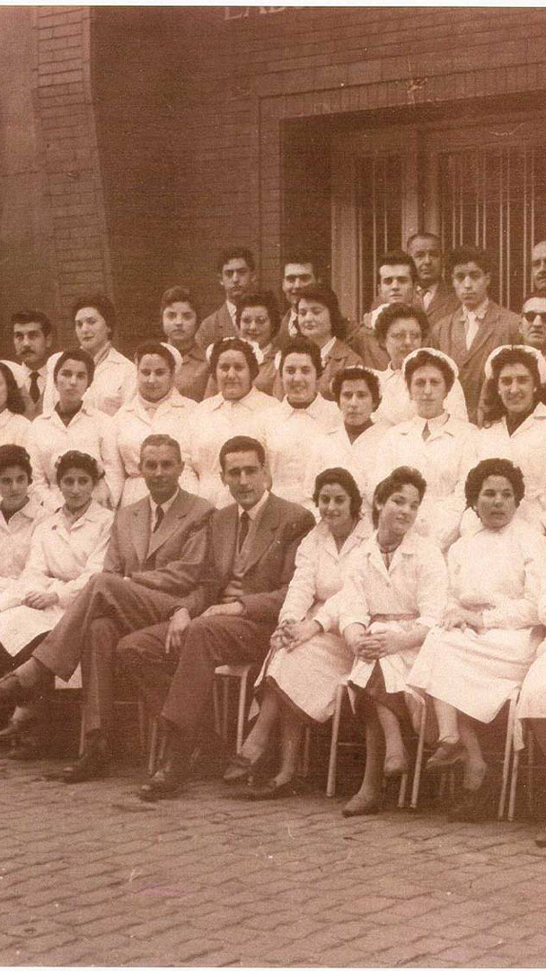 Fotografía antigua del equipo fundacional de trabajadores y personal sanitario en el momento en que nace Ferrer, marcando el inicio de su trayectoria farmacéutica.