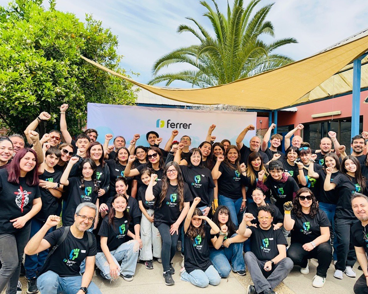 Grupo de personas del equipo de Ferrer posa sonriendo en una actividad corporativa al aire libre, vistiendo camisetas de la compañía.