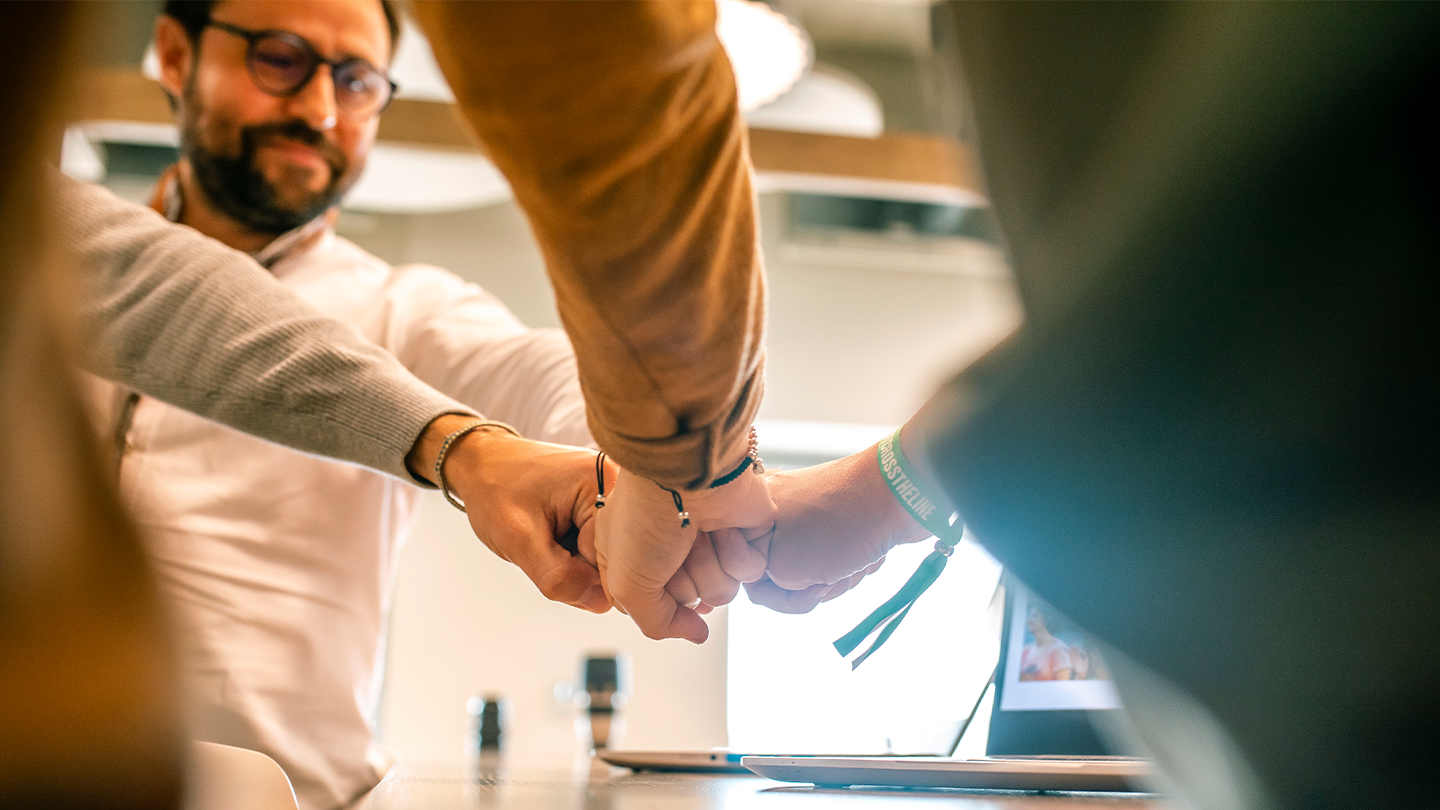 Members of Grupo Ferrer's management team joining fists in a corporate leadership and strategy meeting.