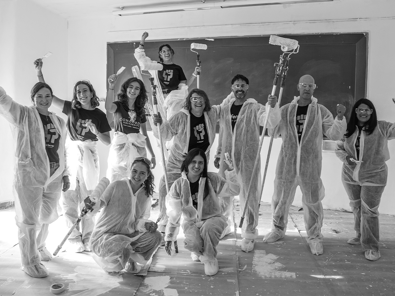 A team of volunteers from Grupo Ferrer in a collective action painting a school classroom during a day of volunteering.