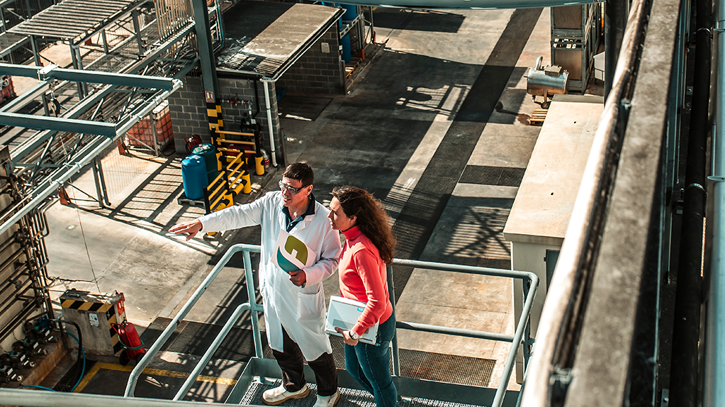 Vista aèria de dos professionals supervisant les instal·lacions de producció d'APIs a la planta química de Ferrer.
